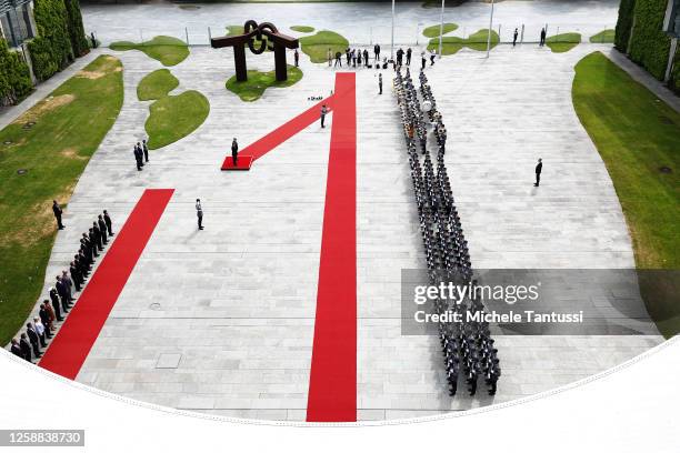 German Chancellor Olaf Scholz and Chinese Premier Li Qiang review a guard of honour upon the arrival of a Chinese government delegation at the...