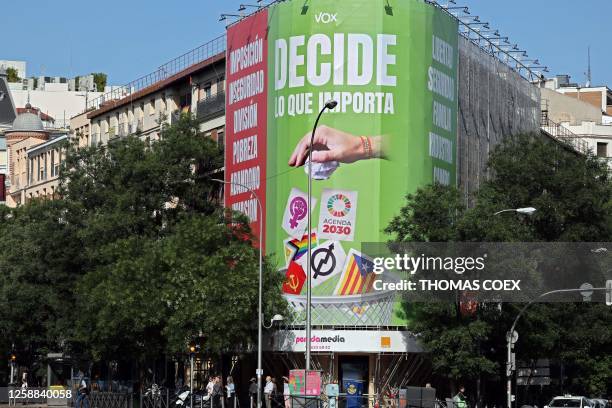 Picture taken on June 20, 2023 shows a billboard of Vox far-right party reading 'Decide what matters' depicting a hand throwing in a bin the Catalan...