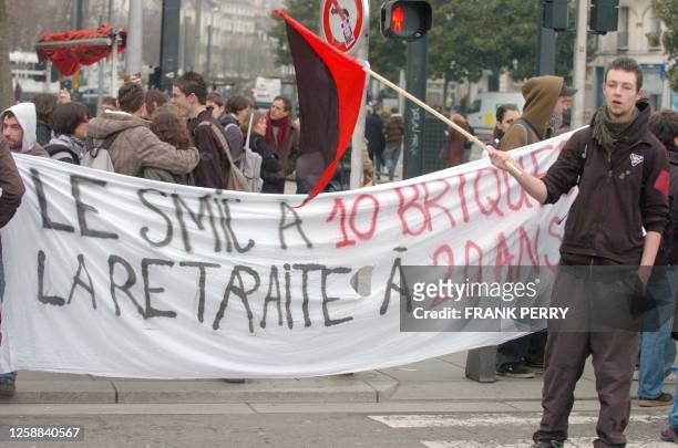 Des jeunes déploient une banderole "Le Smic à 10 briques, la retraite à 20 ans" pendant la manifestation des fonctionnaires qui a rassemblé quelque...