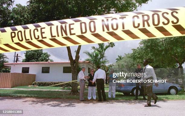 Miami Metro police officers stand 17 July in front of the house of a man who was shot dead inside his home in Miami Springs, FL. Authorities are...