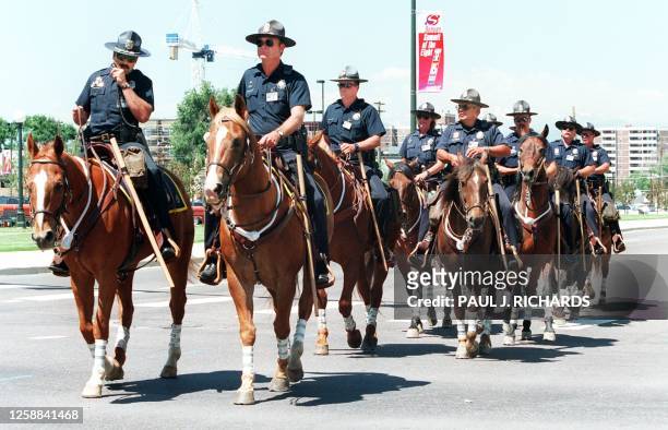 Denver police patrol the streets on horses near the Denver Public Library 20 June in Denver, Colorado one day prior to the start of the Summit of...