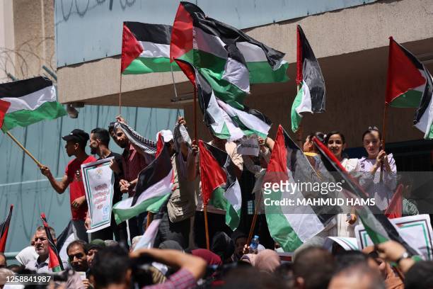 Palestinian refugees gather with national flags outside the United Nations Relief and Works Agency in Gaza City on June 20 to protest cuts in aid.
