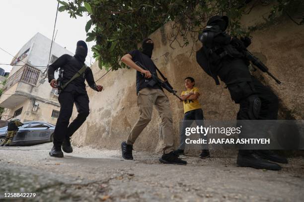 Masked Palestinian gunmen patrol during the funeral of Palestinian Amjad Aref Jaas who succumbed to gunshot wounds sustained in yesterday's Israeli...