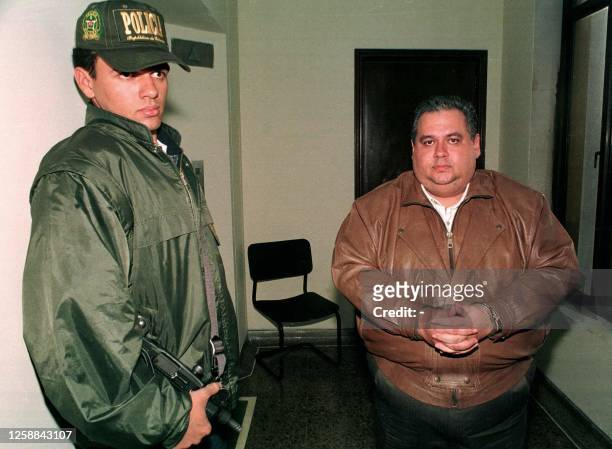 El presuento narcotraficante venezolano Jose Flores Garmendia es escoltado por un miembro de la policia colombiana 20 agosto. Garmendia es pedido en...
