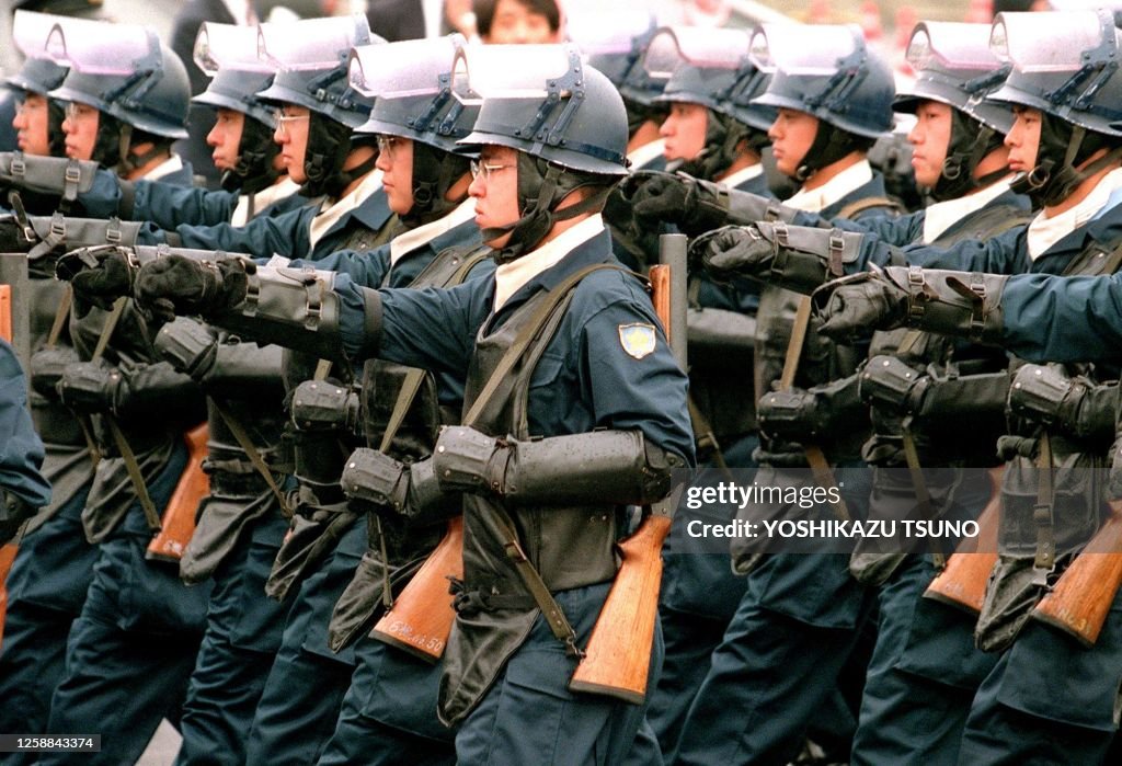 Japan Riot Police Unit Japan's riot police, carrying tear gas rifles, march in review during ...