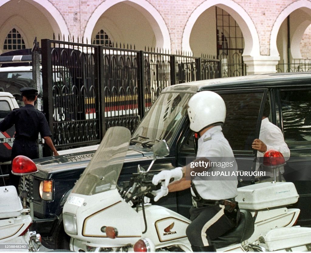 Amwar Rajper Police escort the car which brings detained former deputy primier ...