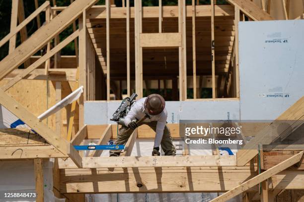 Worker builds a home in Lillington, North Carolina, US, on Thursday, June 15, 2023. The US Census Bureau is scheduled to release housing starts...