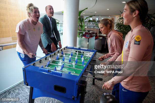 Prince William, Prince of Wales and President of The Football Association, plays table football with England's football players as he visits England...