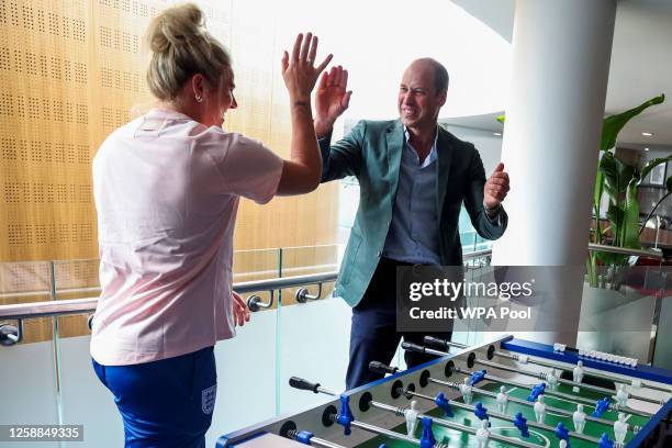 Prince William, Prince of Wales and President of The Football Association, gestures as he plays table football with England's football players,...