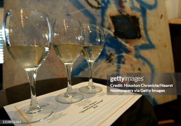 Three different white wines sit on a placemat in front of the painting " Questions of Energy" during a bimonthly series that Patrick Davila is...