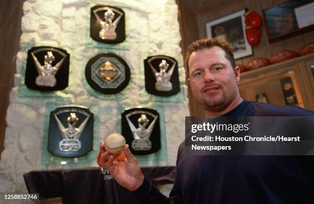 Roger Clemens, named as this year's Cy Young winner, giving him his sixth Cy Young, holds a ball signed by Cy Young, with his first five awards,...