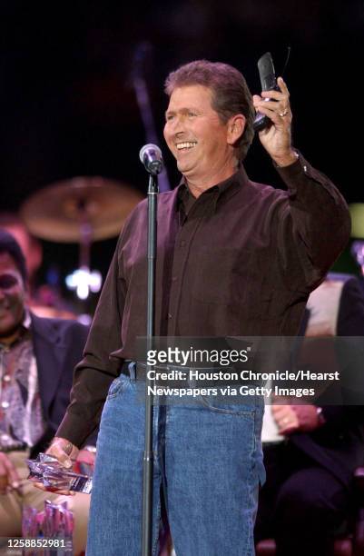 Mac Davis holds up his cell phone, with his mother on the other end of the line as he takes the stage to receive his award before the start of the...
