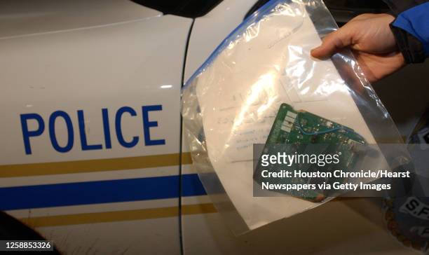 An SFA University Police officer holds a circuit board piece, which was determined to be from the Columbia space shuttle wreckage, which had been...