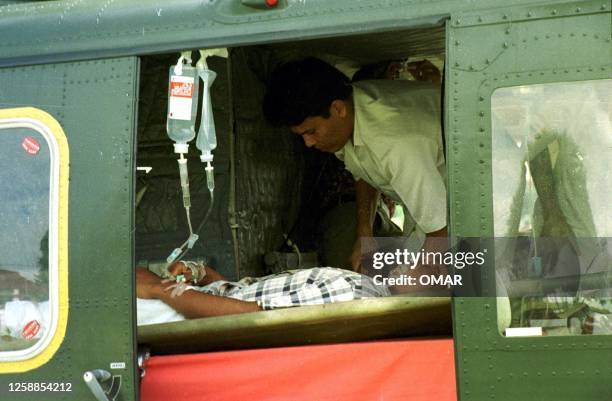 Wounded Indonesian security police officer is loaded aboard a helicopter in Lhokseumawe, in the Indonesian province of Aceh, 26 May 1999, for...