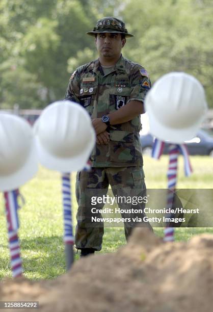 Danny Martinez, POW-MIA representative for the Texas Vietnam Veterans, stands behind a row of shovels with hard hats in preparation for the...