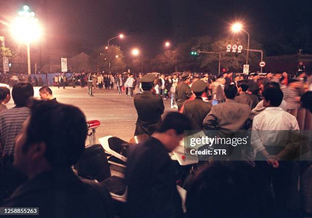 Thousands of protesters walk through an intersection on Changan avenue under a heavy police presence during a demonstration by more than 10,000...