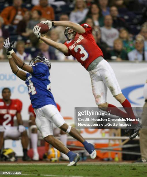 East's, David Ball jumps up to snag a pass over West's, Bo Smith during the 3rd quarter of the Dell East-West Shrine game at Reliant Stadium,...