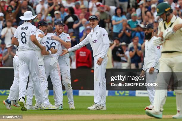 England's Joe Root is congratulated by teammates after catching the ball to take the wicket Australia's wicket keeper Alex Carey for 20 runs on day...