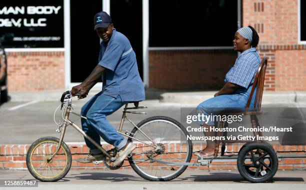 Nicole Babineaux enjoys the ride, sitting in a homemade chair/trailer, as her boyfriend, Jones Bedford, navigates his way up Heights Bld, April 23,...