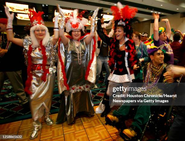 Sisters Janet Schoppe, left, Theresa Schoppe, center, and Marian Schoppe, right dance to "YMCA" during Moody Garden's 24th Annual Mardi Gras Ball for...