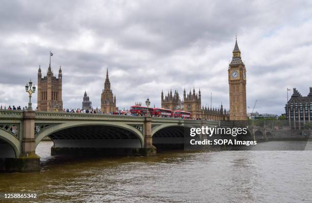 General view of the Houses of Parliament, River Thames and Westminster Bridge on a cloudy day.