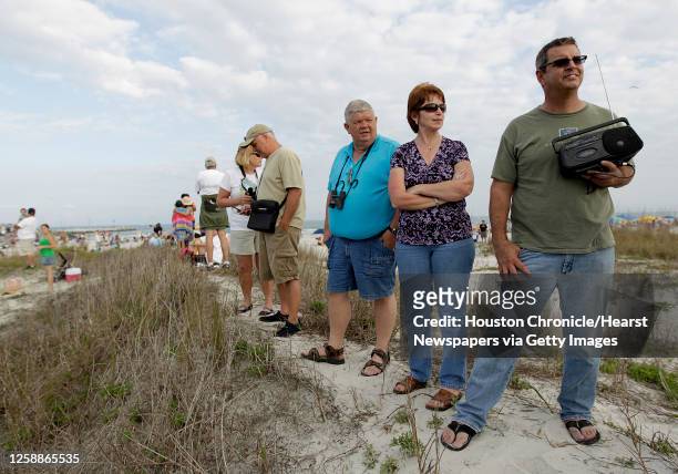 Brad Lott holds a radio as he and others listen to the delay for the space shuttle on the beach at Jetty Park near Cape Canaveral,Thursday, Feb. 24...