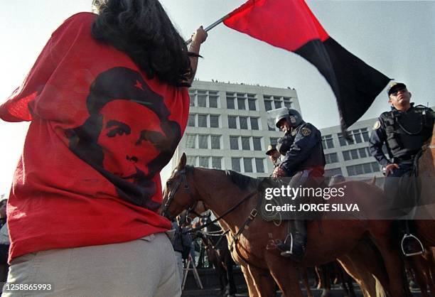 Student of the UNAM waves a strike flag during a march on main avenue of the city, was stopped by a group of anti-riot police and forced to continue...