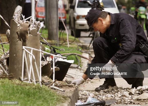 Member of the police inspects the site of an explosive device that exploded leaving four people wounded 09 November 1999, Bogota, Colombia Un miembro...