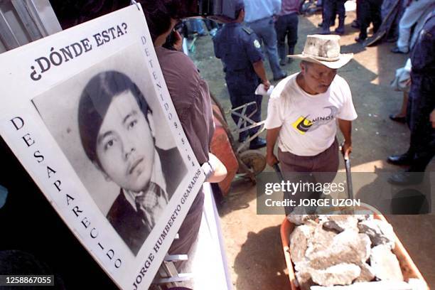 Worker carries stones from the interior of the Academy of Police, where graves have been exumed, Guatamala City, Guatamala, 06 October1999. Un...