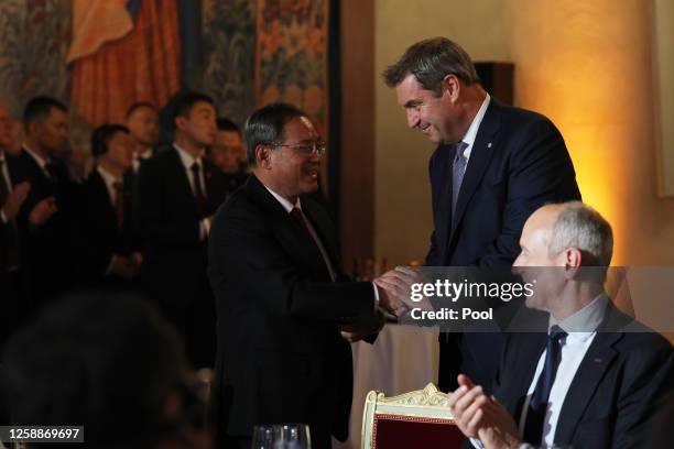 Chinese Premier Li Qiang shakes hands with State Premier of Bavaria Markus Soeder during a festive dinner at the Kaisersaal of Munich Residence on...