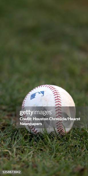 Baseball lies in the grass at the Oseola County Stadium, Tuesday, Feb. 12 in Kissimmee, as pitchers and catchers got their first official workout...