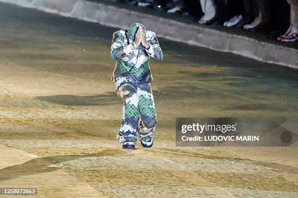 Louis Vuitton' fashion designer and singer Pharrell Williams joins hands as he acknowledges the audience at the end of the Louis Vuitton Menswear...