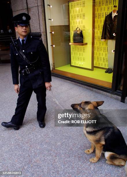 Policeman with his police dog takes a break from patrol at an intersection in Hong Kong, 06 February 2001. The 5-year-old German Shepard police dog...