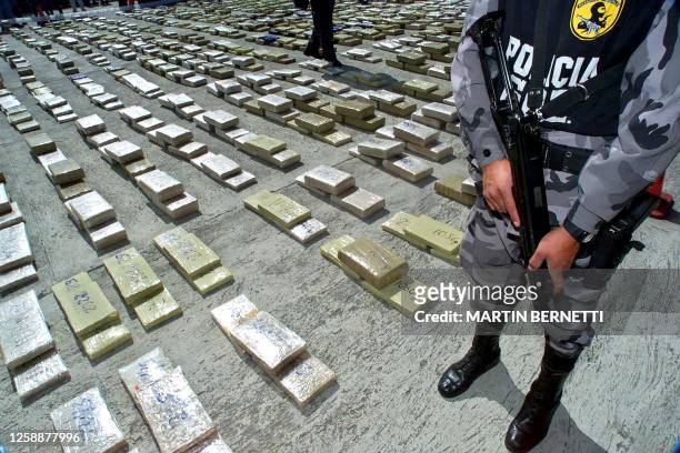 Marijuana packages are displayed by Bolivian police 28 November 2000 in Quito confiscated during Operation Galaxy. Un policia antinarcotico vigila...