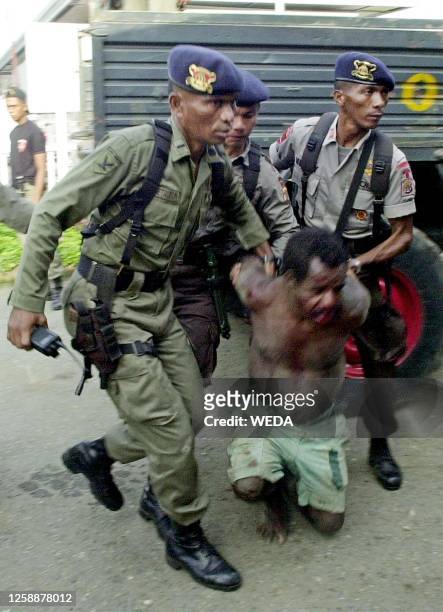 Indonesian Policemen arrest a Papuan suspected of involvement in an early morning attack at Abepura market in the outskirt Capital of Jayapura 07...