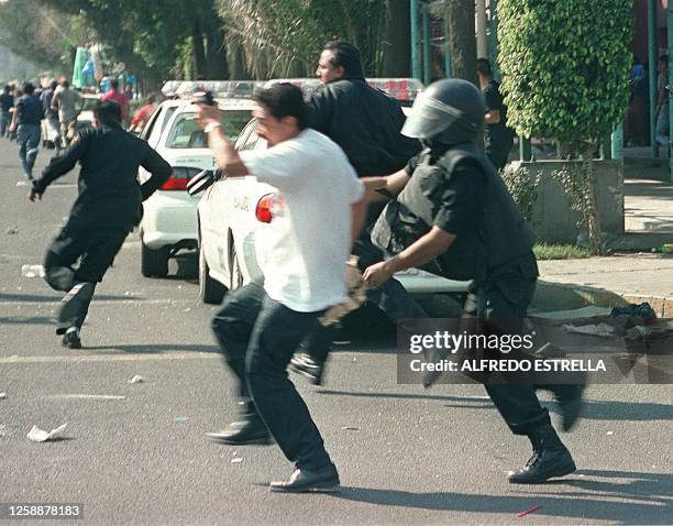 Police officer tries to catch a man in the " brave district " of Tepito, during the confrontations between the police and retailers, Mexico City,...