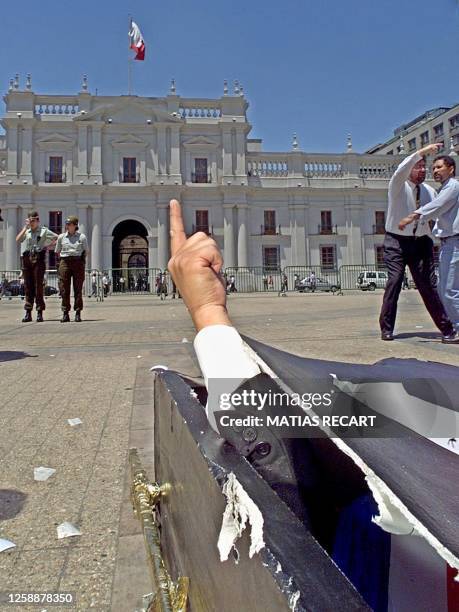 One of thousands of public employees on strike pretends to be Chilean President Ricardo Lagos in a coffin 30 November during a demonstration in front...