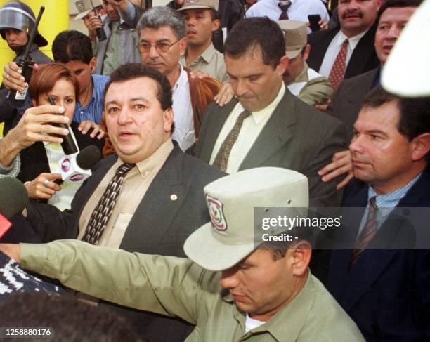 Benjamin Maciel Pazzoti and Carlos Maggi are lead by police following their arrest 19 May 2000 in Asuncion for their alleged involvement in the...