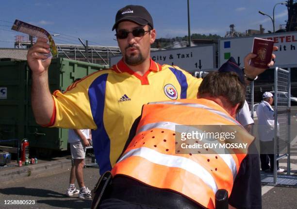 Romanian supporter holds his Euro 2000 ticket and his passport during a control by a Belgian State Policeman12 June 2000 in Liege , prior to the...