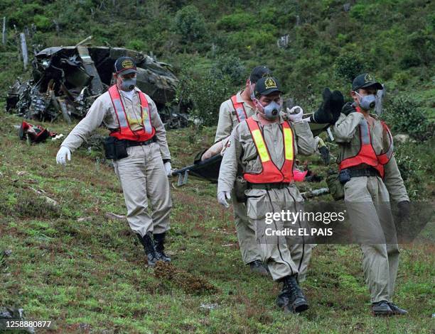 Members of the police team transport one of the bodies of the helicopter crash caused by guerillas soldiers in Tulua, Columbia, 06 April 2000....