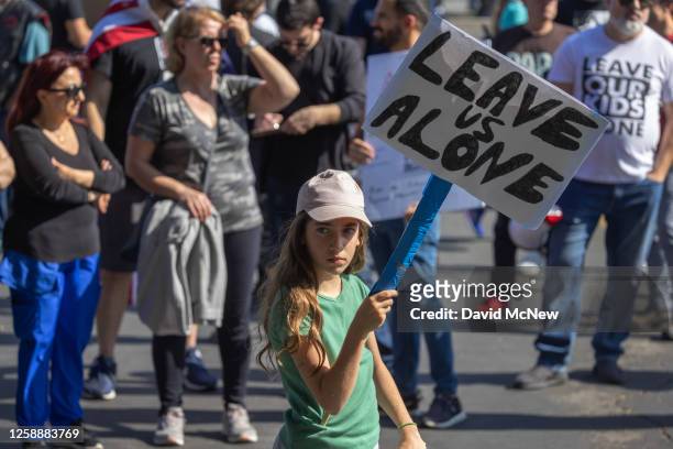 Girl holds a sign reading "Leave Us Alone" among anti-LGBTQ+ demonstrators outside a Glendale Unified School District Board of Education meeting on...