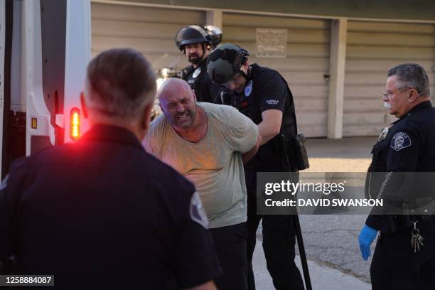 Police detain a demonstrator as they gather outside the Glendale Unified School District headquarters in Glendale, California, on June 20, 2023. Over...