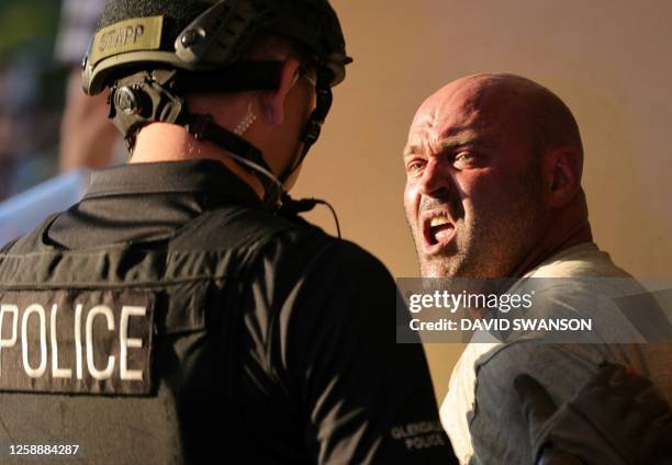 Police detain a demonstrator as they gather outside the Glendale Unified School District headquarters in Glendale, California, on June 20, 2023. Over...