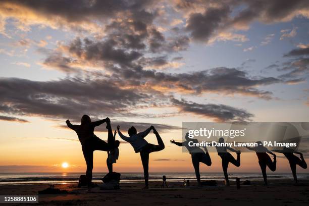 Members of the Happy Seal Yoga class practice on Cayton Bay in Scarborough as the sun rises to celebrate the Summer Solstice. Picture date: Wednesday...