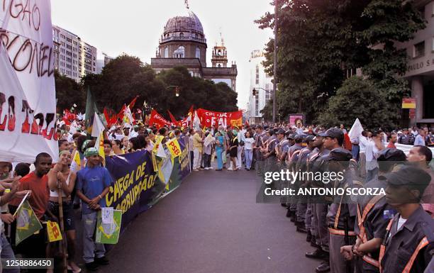 Military police form a line, 12 June 2001, to control a protest against corruption and energy rationing, on the main avenue in Rio de Janeiro,...