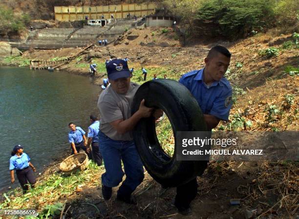 The vice-mayor of Managua, Heberthy Carcamo , helps a cadet of Policia, to remove a rim from the borders of the Lagoon of Tiscapa, in Managua, the 12...