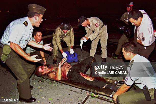 Police officers and rescuers help a person, injured by the explosion of a bomb-car in Cali, Colombia, 04 May 2001, 36 persons were injured. Policias...