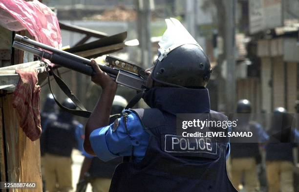 Policeman aims a gun at opposition activists during clashes in the capital Dhaka 03 April 2001 during the last day of three-day long non-stop...