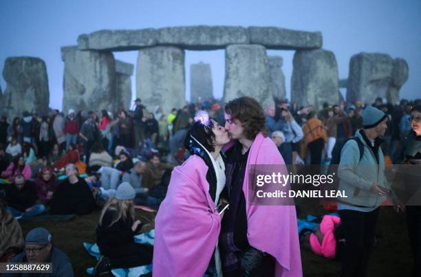 Revellers stand by the stones as they wait for the sun to rise at Stonehenge, near Amesbury, in Wiltshire, southern England on June 21 to celebrate...