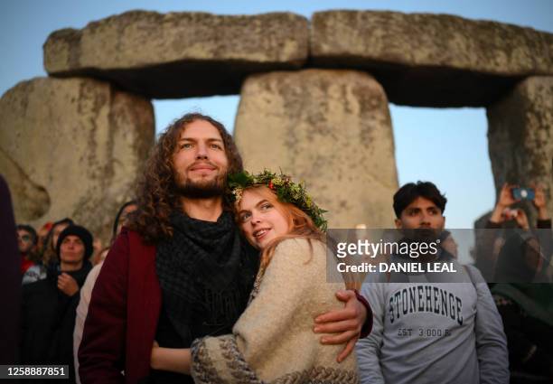 Revellers celebrate the Summer Solstice as the sun rises at Stonehenge, near Amesbury, in Wiltshire, southern England on June 21 in a festival, which...